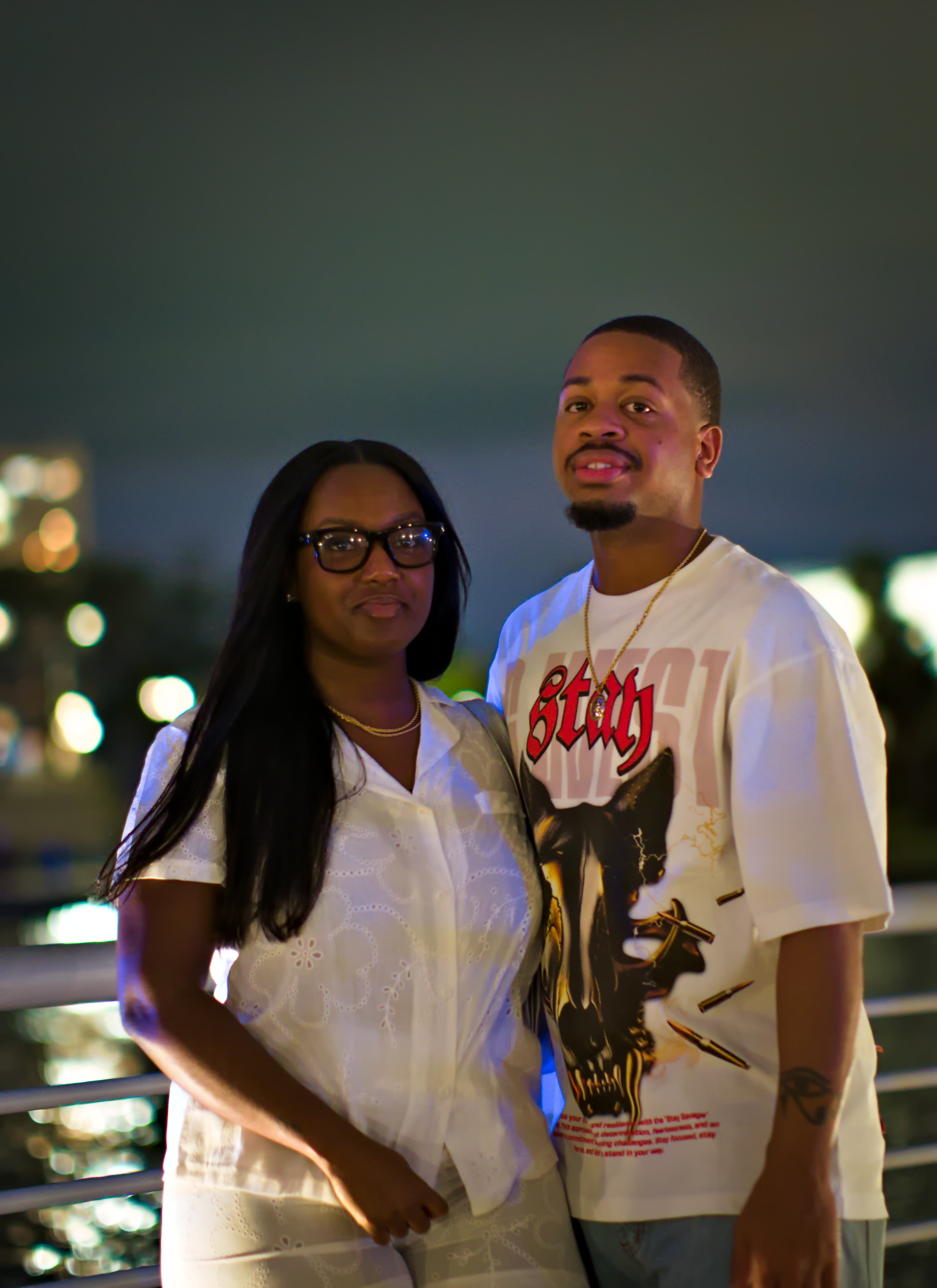 Two people standing together with a cityscape in the background. Acacia Cinematography, Tampa, Fl 