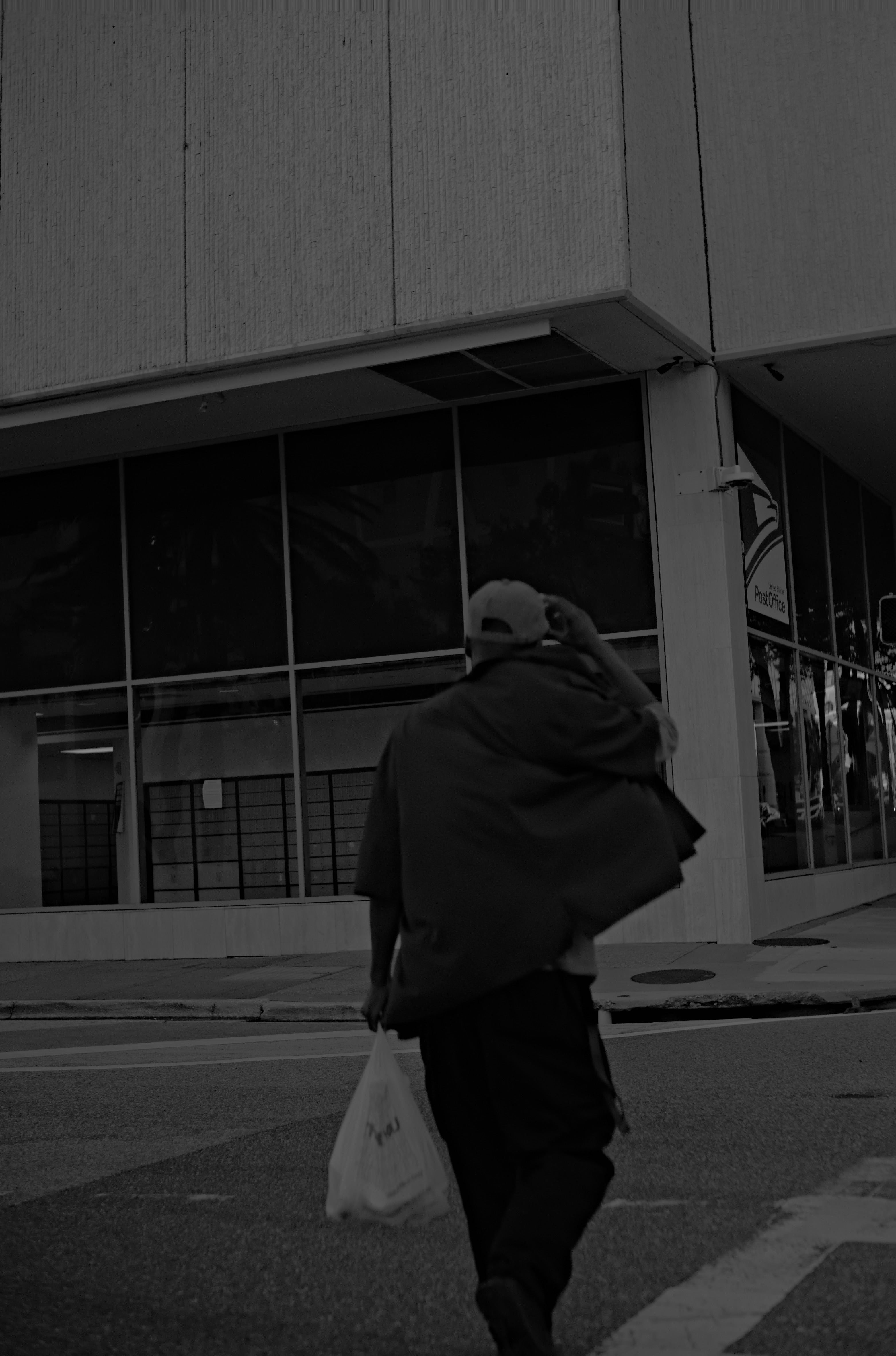 Person walking on a street with a building in the background. Acacia Cinematography, Tampa, Fl 